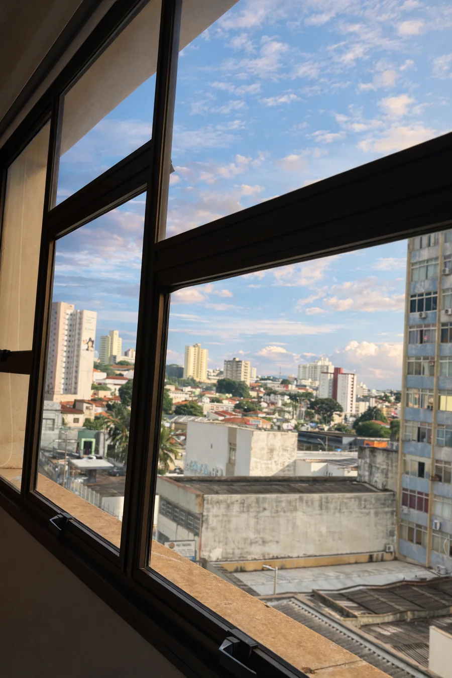 Janela da sala 605, no sexto andar, com o céu e os prédios de Uberaba